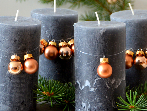 Adventskranz mal anders: 4 Kerzen auf einer Betonplatte.