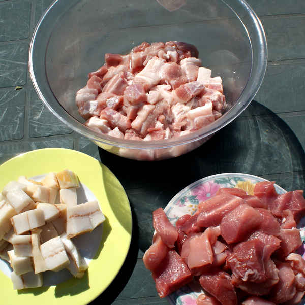Schneide für die Bratwürste das Fleisch in grobe Stücke.