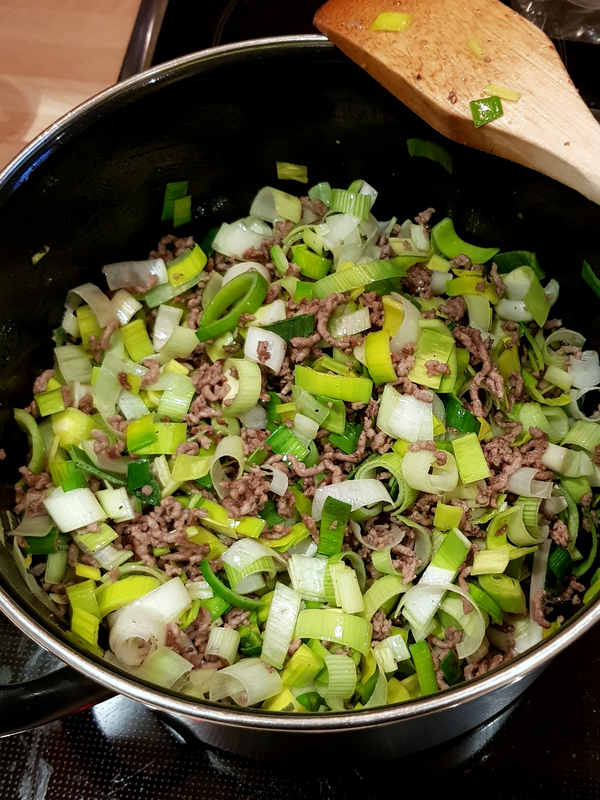 Für den Gnocchi-Auflauf mische Hackfleisch, Lauch, Salz und Peffer.