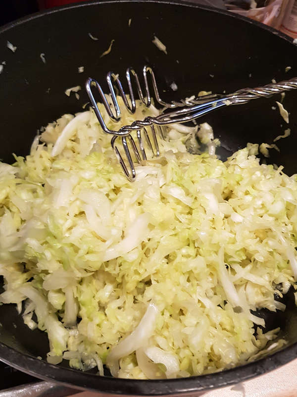 Stampfe den Kohl für leckeres selbst gemachtes Sauerkraut.